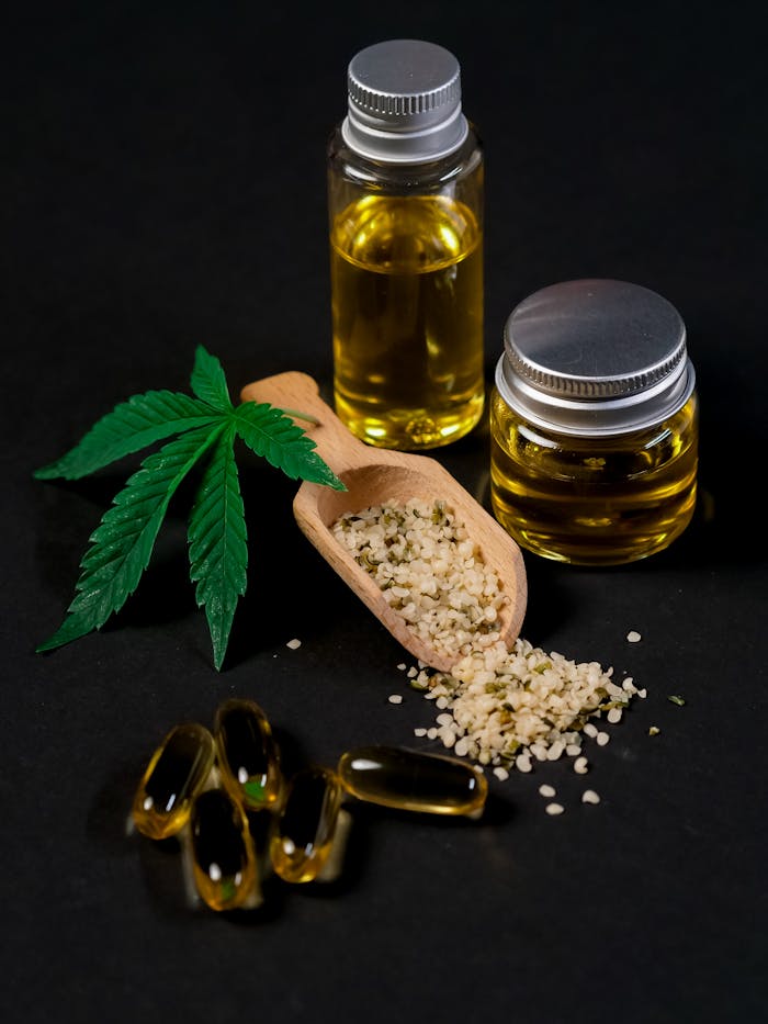 A set of CBD products including oil, capsules, hemp seeds, and a cannabis leaf, presented on a dark backdrop.
